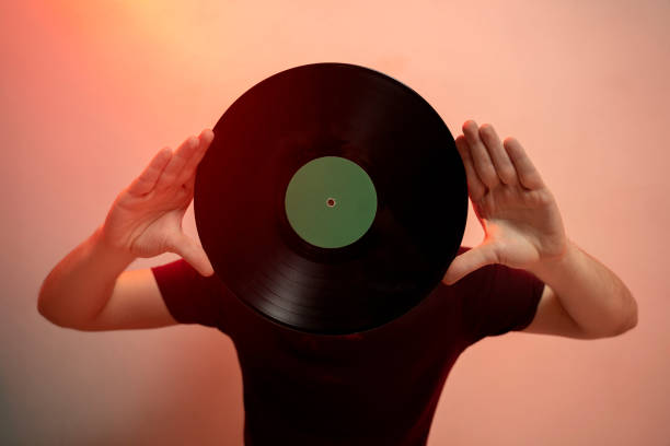 istock Man covering face with music record 1179637855
