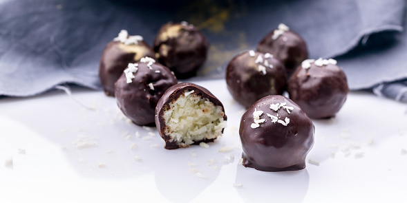 Handmade chocolates with coconut and honey. Gourmet chocolate on a white background
