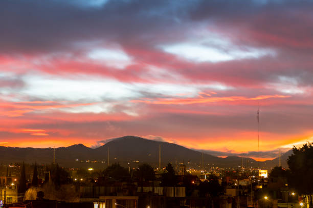 Orange skies over city hills on background