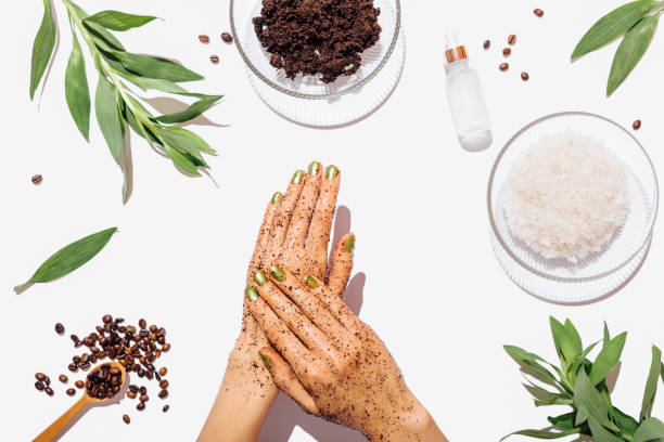 Woman's hands massaging natural homemade coffee scrub Woman's hands massaging natural homemade coffee scrub with coconut oil on white table next to ingredients, view from above. scrubs stock pictures, royalty-free photos & images