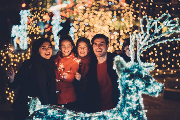 Happy family on Christmas with burning sparklers Young family with two kids celebrating New Year new year urban scene horizontal people stock pictures, royalty-free photos & images