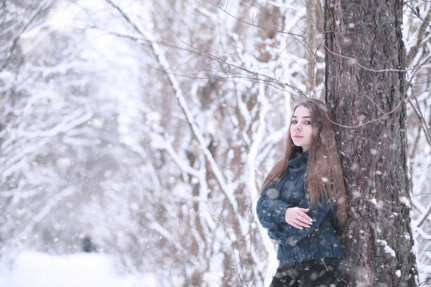 istock Girl in a winter park in snowfall 1179643264