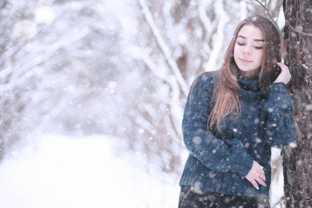 istock Girl in a winter park in snowfall 1179643291