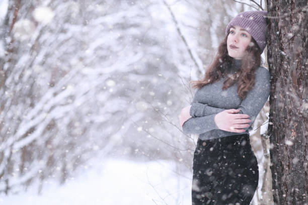 istock Girl in a winter park in snowfall 1179643306