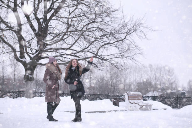 istock Girl in a winter park in snowfall 1179646167
