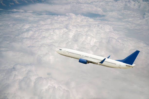 Passenger jet airplane flying above clouds