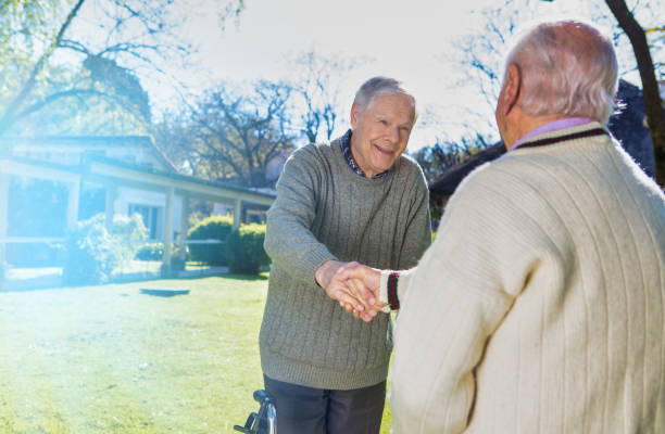 istock Neighborhood. Handshake between retired neighbors 1179648555