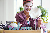Young woman applying facial mask.