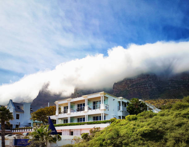 Cape town Camps Bay 12 apostles hotel under mist covered mountain peaks and a relatively blue sky.