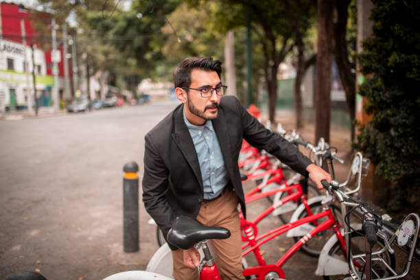 Man in business wear renting a bike The young businessman renting a bike at bicycle-sharing system rent a bike stock pictures, royalty-free photos & images