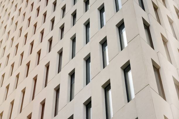 istock Perspective view of geometric angular concrete windows on the facade of a modernist brutalist style building surface with sunlight. 1179660834