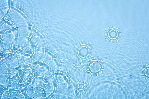 circle ripple waves from rain droplet on water surface as textured background