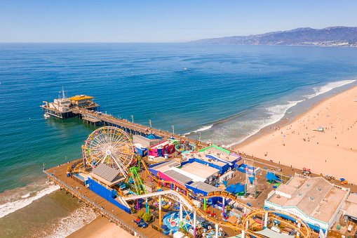 Aerial view of Santa Monica Pier, California - USA. Beautiful amusement park with ferris wheel and roller coaster.