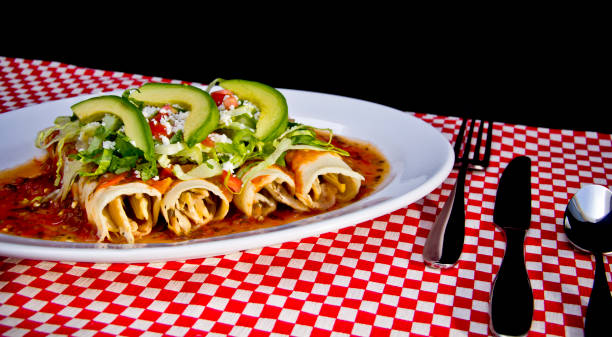 istock Red Enchilada with avocado slices and crumbled cheese 1179664012