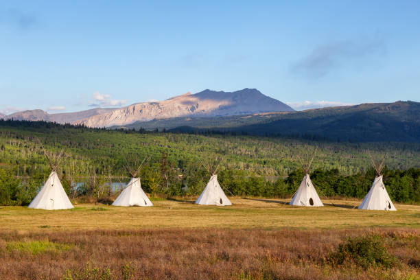 tipi in einem feld mit amerikanischer rocky mountain landscape - teepee first nations nature camping stock-fotos und bilder