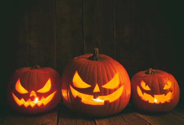 istock Pumpkins carved for Halloween on Rough Wood Table. 1179666566