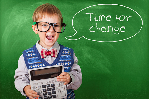 Nerd Schoolboy Wearing Glasses Holding Calculator In Front Chalkboard, Back To School