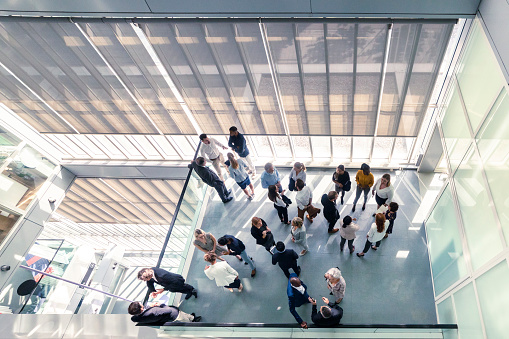 A high-angle view of a group of business people standing in the office building