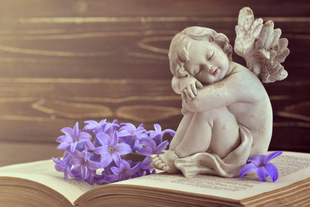 istock Guardian angel and hyacinth flower on old book 1179667916