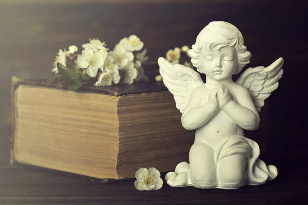 istock Guardian angel, spring flowers and old book 1179667978