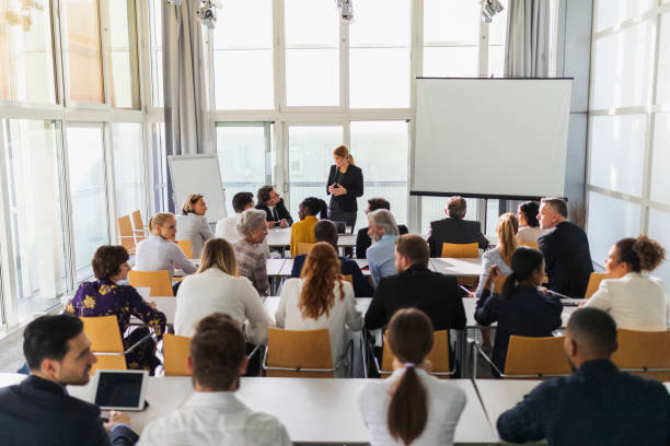 Business team attending a meeting Business team attending a meeting in the lecture hall attending photos stock pictures, royalty-free photos & images