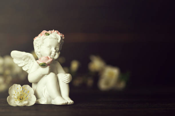 istock Little guardian angel holding flowers 1179671946