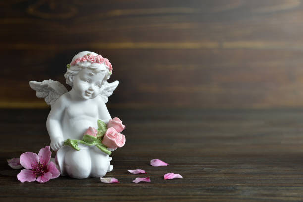 istock Angel and spring flowers on wooden background 1179671950