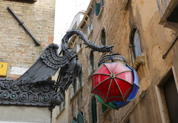 Old European street lamp with three pink lights set against blue sky