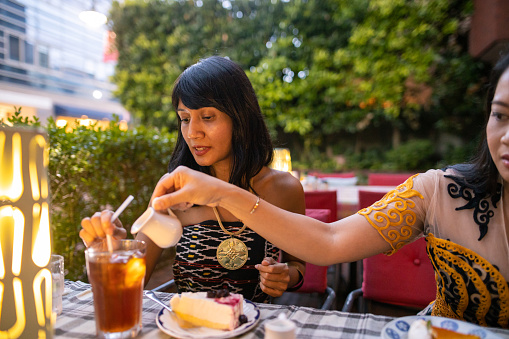 Asian women taking a tea break at outdoor cafe
