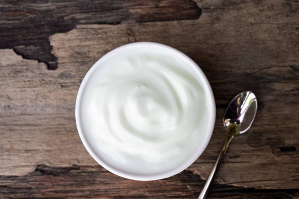 istock Yogurt white put in a glass put on a wooden background from top view. 1179676200