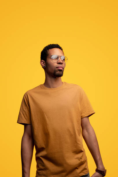 istock Black man in yellow t-shirt on yellow background 1179680228