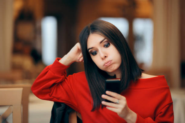 Bored Woman Checking her Smartphone on a Date Girlfriend checking her phone while her boyfriend is running late waiting telephone on the phone frustration stock pictures, royalty-free photos & images