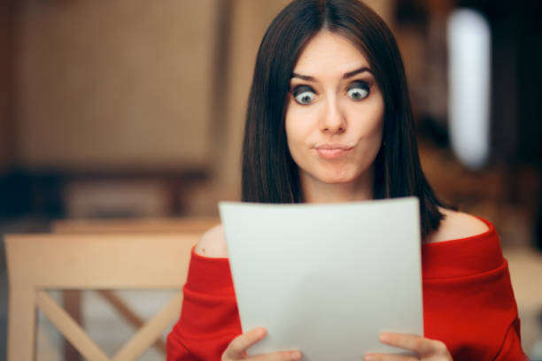 mujer sorprendida leyendo documentos legales en un restaurante - fine print fotografías e imágenes de stock