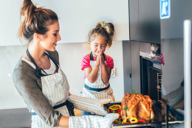 istock Mother and daughter preparing turkey 1179697409