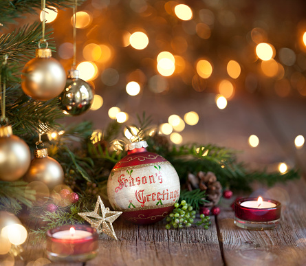 Christmas tree with baubles and lights against an old wood background