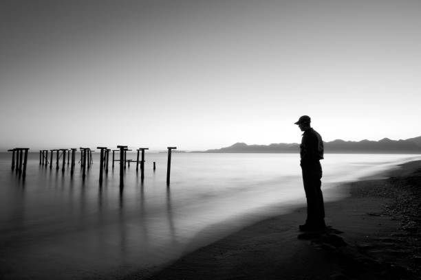 istock Long Exposure Of Man Watching Waves Under Old Pier 117971277
