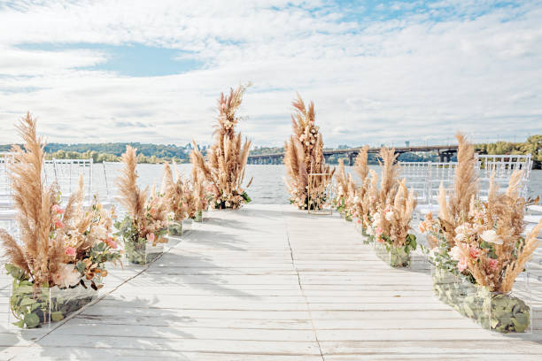 boda junto al río. lugar de bodas en la playa. escenario de madera con arco de decoraciones florales - wedding venue fotografías e imágenes de stock