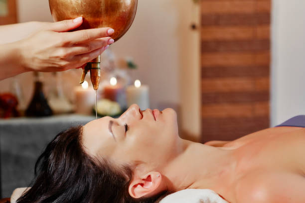 a unique ayurvedic procedure shirodhara that elevates you to a state called trance. the flow of pleasant sensations covers your entire body, you relax both physically and spiritually. - ayurveda massaging aromatherapy chakra imagens e fotografias de stock