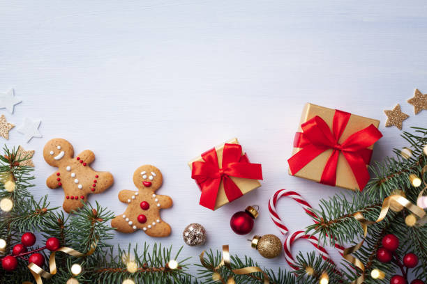 istock Christmas background with gingerbread man, gift boxes and fir tree top view. 1179720780