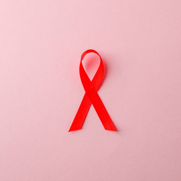 świadomość aids czerwona wstążka na różowym tle. koncepcja światowego dnia pomocy, symbol ludzkiej choroby wirusa niedoboru odporności - immunodeficiency zdjęcia i obrazy z banku zdjęć