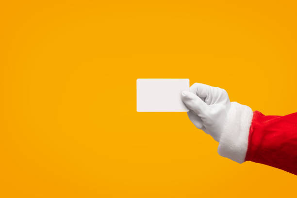istock Santa Claus hand holding plastic credit card over isolated background. 1179730041