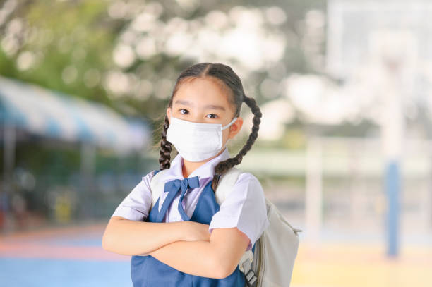 школьница в маске для рта против загрязнения смога воздуха в городе бангкок, таиланд - pollution street city street fog стоковые фото и изображения