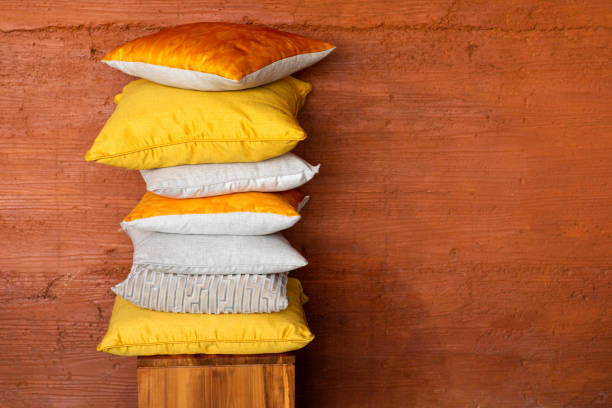 pillows on chair against orange wall. - scandic imagens e fotografias de stock