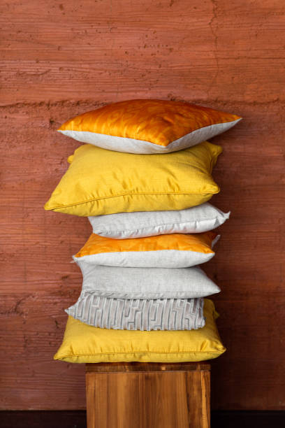 istock Pillows on chair against orange wall. 1179733084