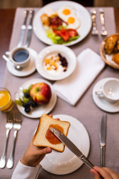 istock Young woman spreading jam on a toast 1179735555
