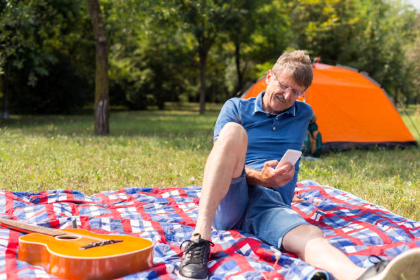istock Senior man using smart phone on picnic 1179736927