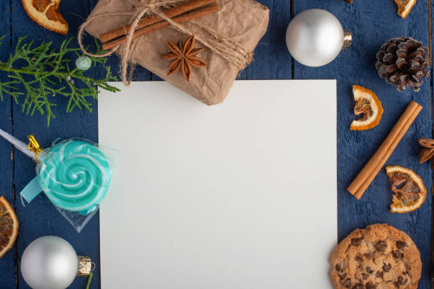 istock Christmas composition with white blank square card and fir branches and pine cones. On a blue wooden background, Flat lay, top view 1179736964