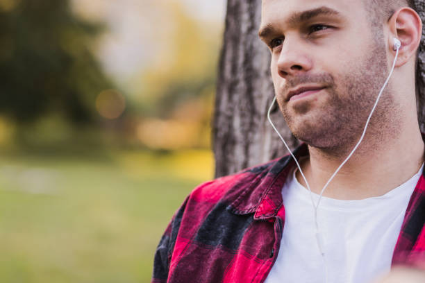istock Young man wearing in-ear headphones 1179737406