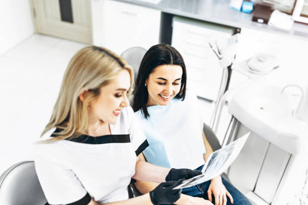 istock Dentist showing x-ray for the patient and explaining plan of treatment. 1179741470