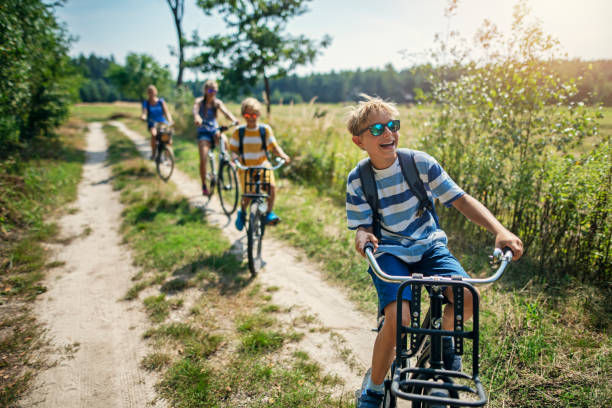 famiglia che si gode un viaggio in bicicletta - childhood lifestyles caucasian expressing positivity foto e immagini stock